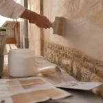 Peinture extérieur à la chaux sur façade, artisan à la brosse à badigeonner